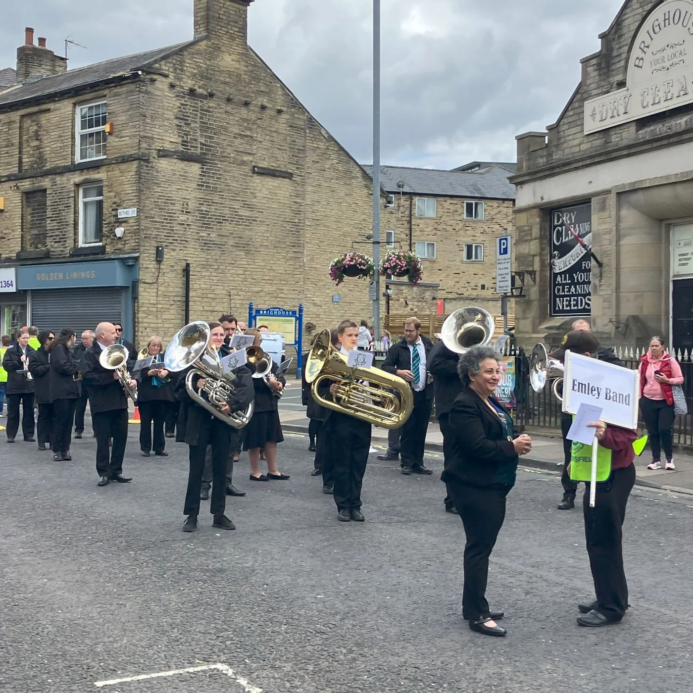 Emley Brass Band marching along the street at Brighouse in 2023.