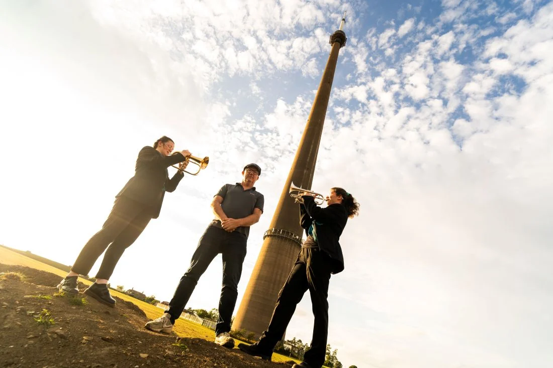 Emley musicians playing beneath Emley Moor mast for Yorkshire Day in 2026. Image via Huddersfield Hub.